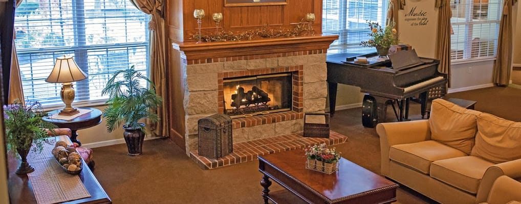 A cozy living room with a fireplace and piano