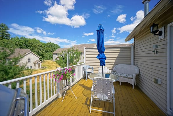 A sunny patio with seating and potted flowers at Black Rocks Village