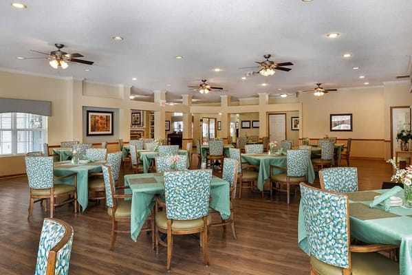Dining area with tables and chairs in a senior care facility
