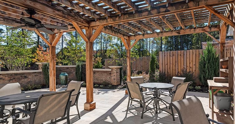 Wooden pergola covering a seating area with tables and chairs