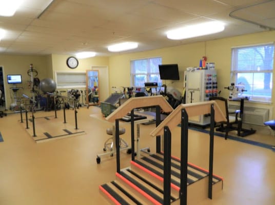A physical therapy room equipped with exercise equipment and stairs.