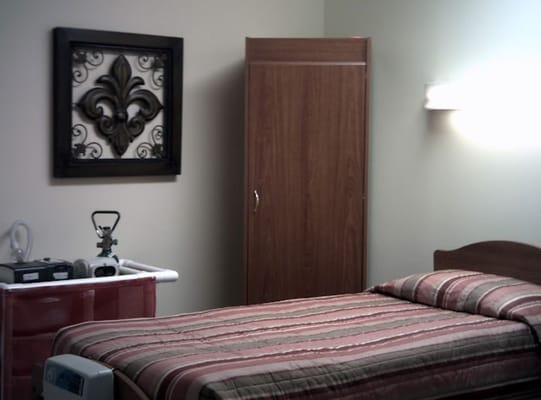 A neatly arranged bedroom with a bed, dresser, and wall decor.