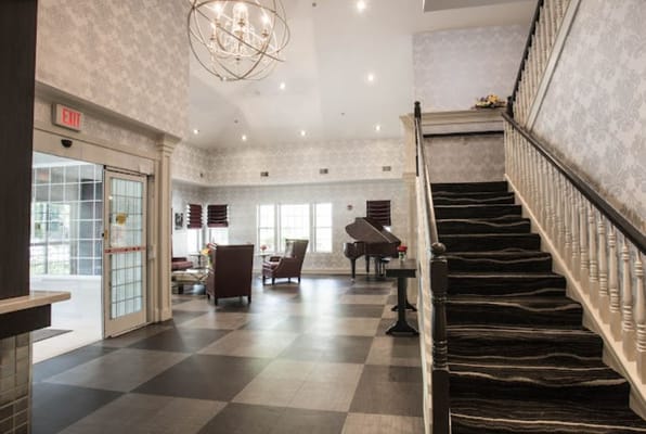 Interior view of a lobby with a staircase and seating area
