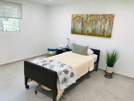 A well-decorated resident room with a bed and artwork