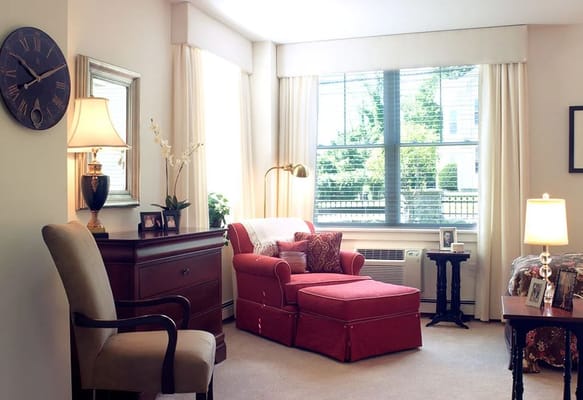 Cozy interior room with a red chaise lounge and a window