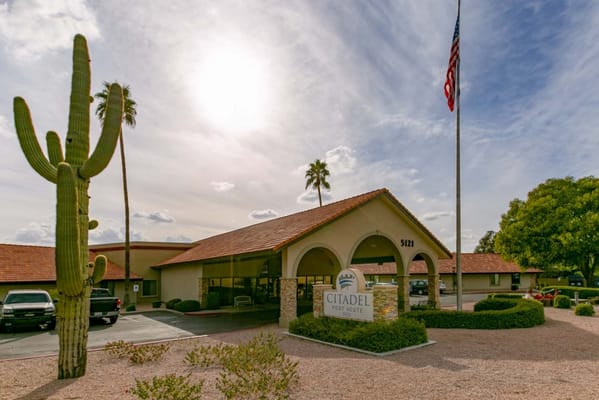 Exterior view of Citadel Post Acute with palm trees and sign
