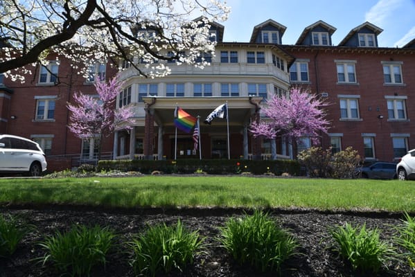 Exterior view of a senior living facility with flowering trees