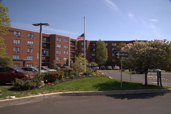 View of the building's exterior with flag and landscaped garden.