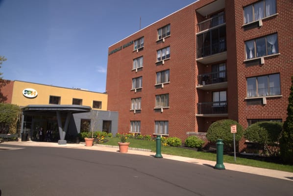 Main entrance of a senior living facility with landscaped gardens
