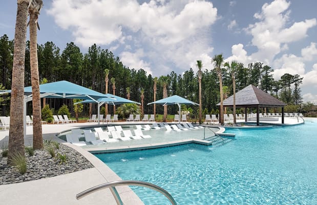 Outdoor pool area with lounge chairs and palm trees