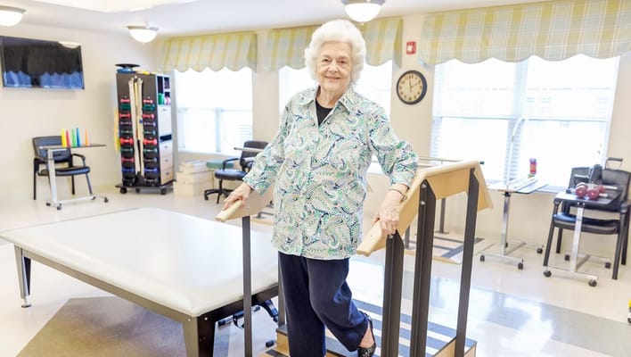 A resident participating in a therapy session in a bright room.