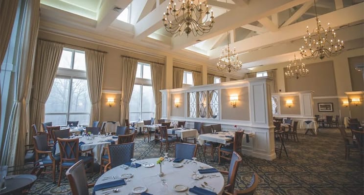 Spacious dining room with chandeliers and tables set for dining