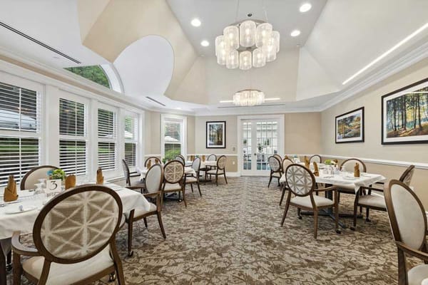 Dining room with tables set for meals in a bright, airy space