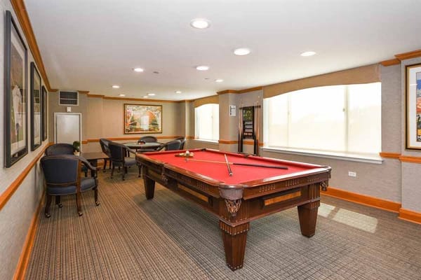 A pool table in a well-lit room with seating and artwork