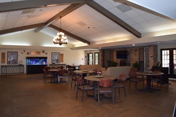 Spacious lounge area with tables, chairs, and an aquarium