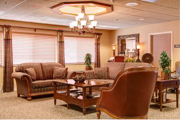 A cozy living room with striped sofas, a wooden coffee table, and decorative plants