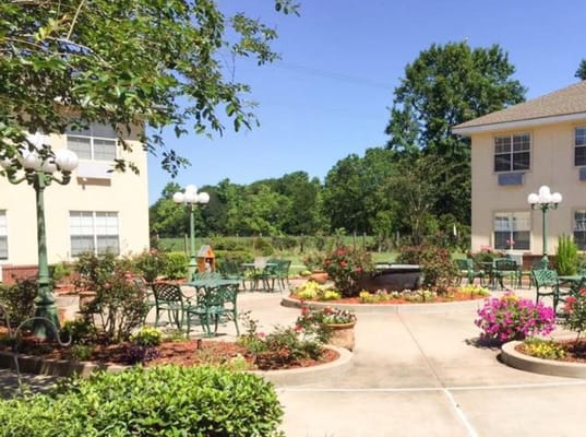Beautiful courtyard with seating and flowers at Garden View Assisted Living