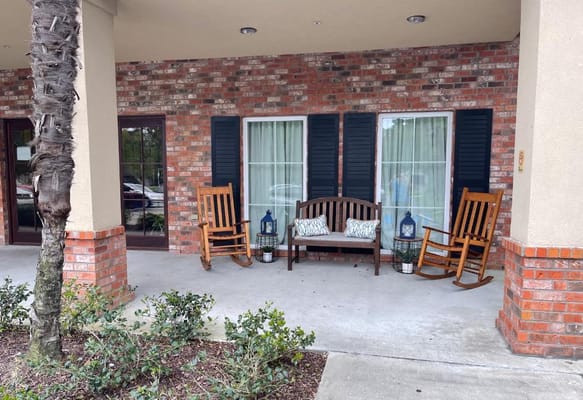 Outdoor seating area with rocking chairs and plants