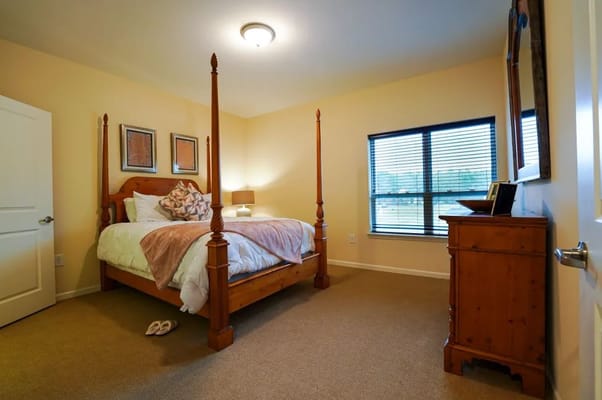 Bright and inviting bedroom with a four-poster bed and wooden furniture.