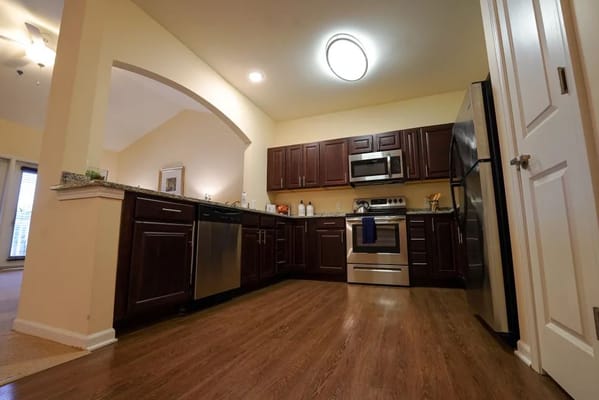 Spacious kitchen with stainless steel appliances and dark cabinetry