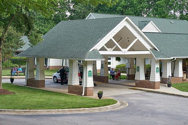 Exterior view of the facility entrance with residents sitting outside