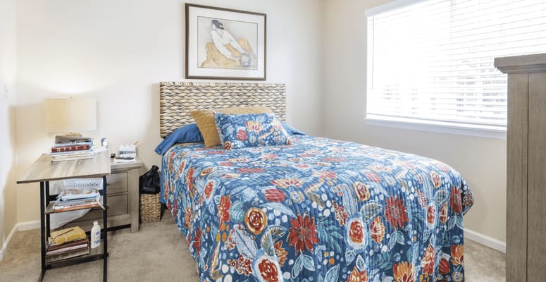 Cozy resident room featuring floral bedding and artwork