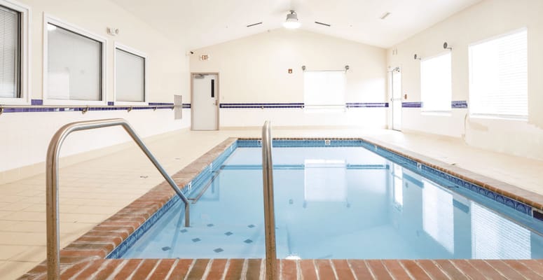 Indoor swimming pool area with clear water and tile flooring