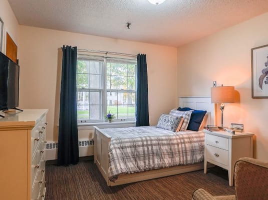 Comfortable bedroom with a large window in The Auberge at Missoula Valley