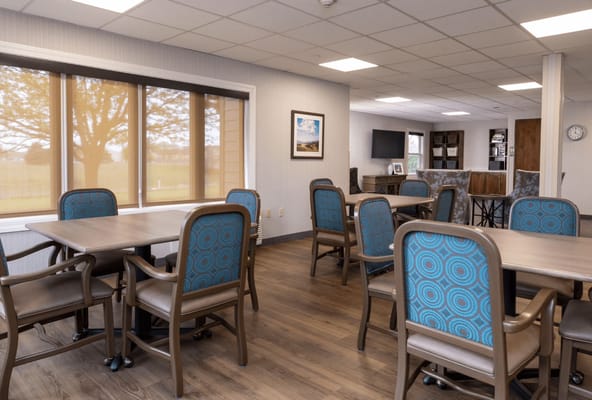 Common area with tables and chairs in a well-lit room