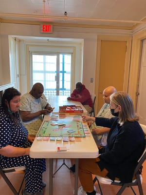 Group of elderly residents playing Monopoly at a table
