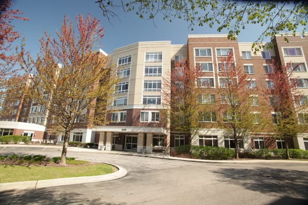 Front view of Autumn Green senior living facility with trees and pathway