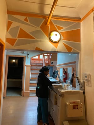 Staff member at the reception desk in a colorful hallway