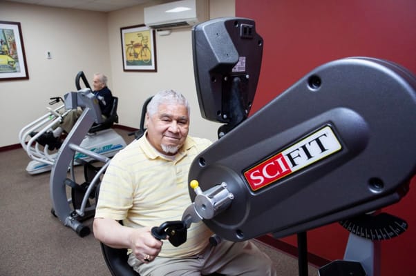 A resident using fitness equipment in an exercise room