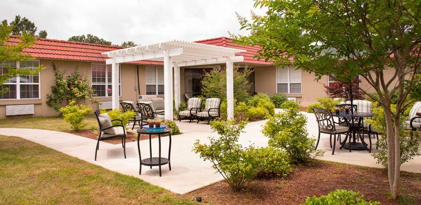 Outdoor seating area with gardens and shaded pergola