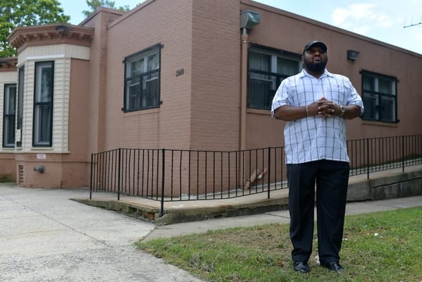 A staff member standing in front of the facility building