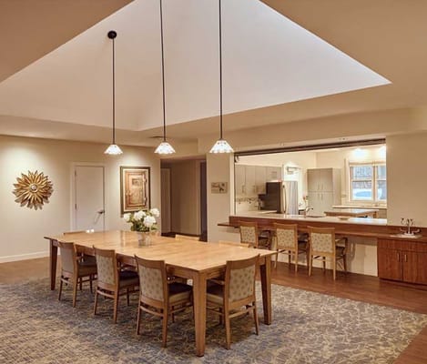 Bright dining area with large table and kitchen view