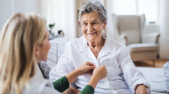 Healthcare worker assisting senior resident in a cozy interior