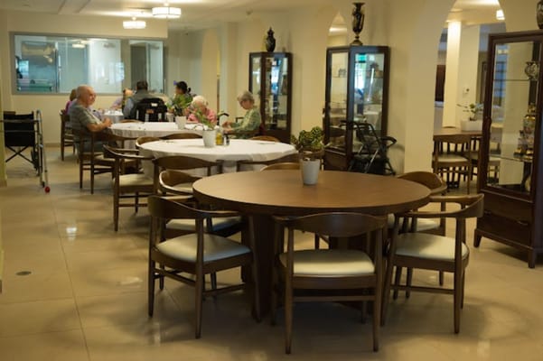 Residents enjoying a communal dining area with tables