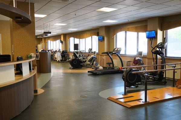 Well-equipped indoor fitness area with residents exercising