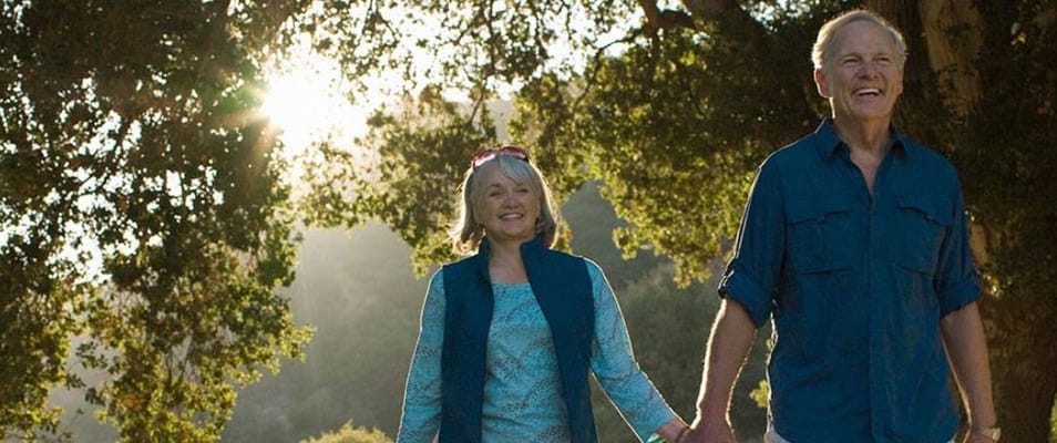 Couple walking together in a sunny outdoor setting