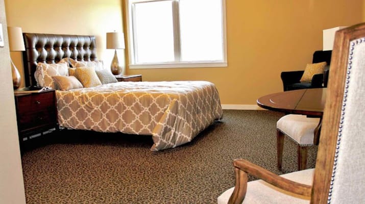 Cozy interior of a resident room with a bed and seating area