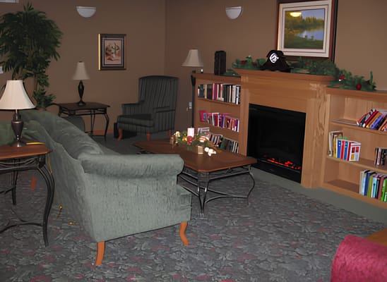 Cozy living room featuring a green sofa, armchair, and bookshelf