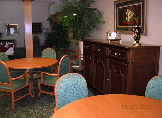 Inside view of the common area with tables and a wooden cabinet.