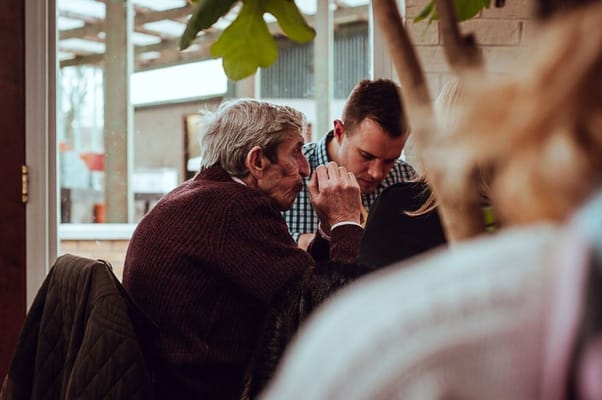 Two individuals sharing a conversation in a cozy setting.