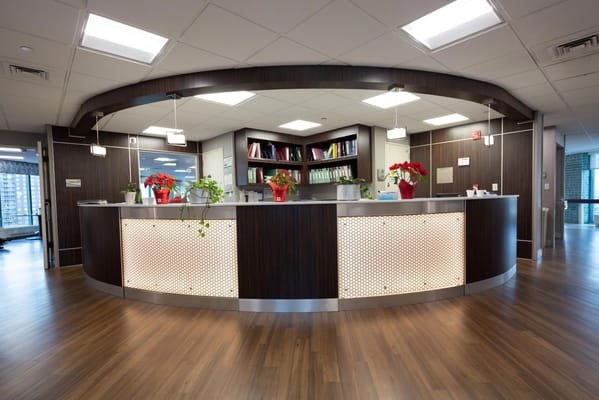 Modern reception desk with plants and files in a senior living facility.