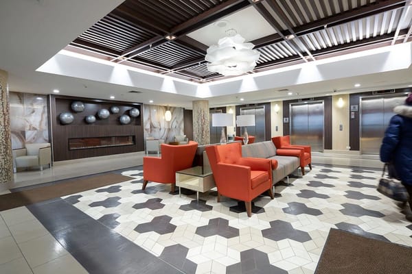 Modern lobby with orange chairs and elevator banks