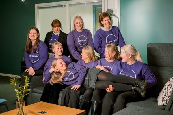 Staff members smiling together in Seurana Oy sweatshirts