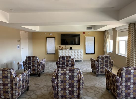 Lounge area with patterned chairs and a TV in Silver Birch at Cook Road