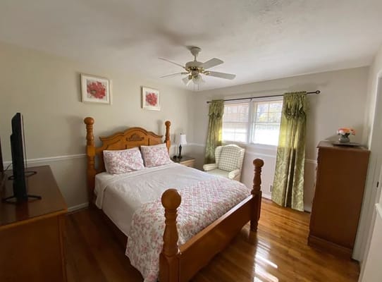 Bright and inviting bedroom with wooden furniture and floral decor