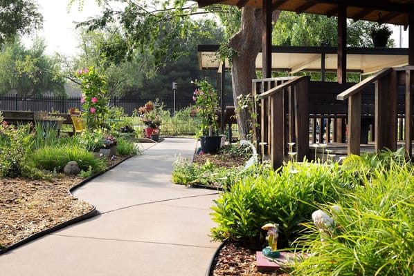 Flower-lined garden pathway with wooden seating area